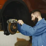 Mechanic inspecting a car braking system for brake noise