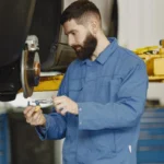 Mechanic inspecting a car brake assembly in a workshop