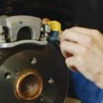 Mechanic working on a car brake disc and caliper