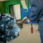 Mechanic working on a car transmission in a workshop